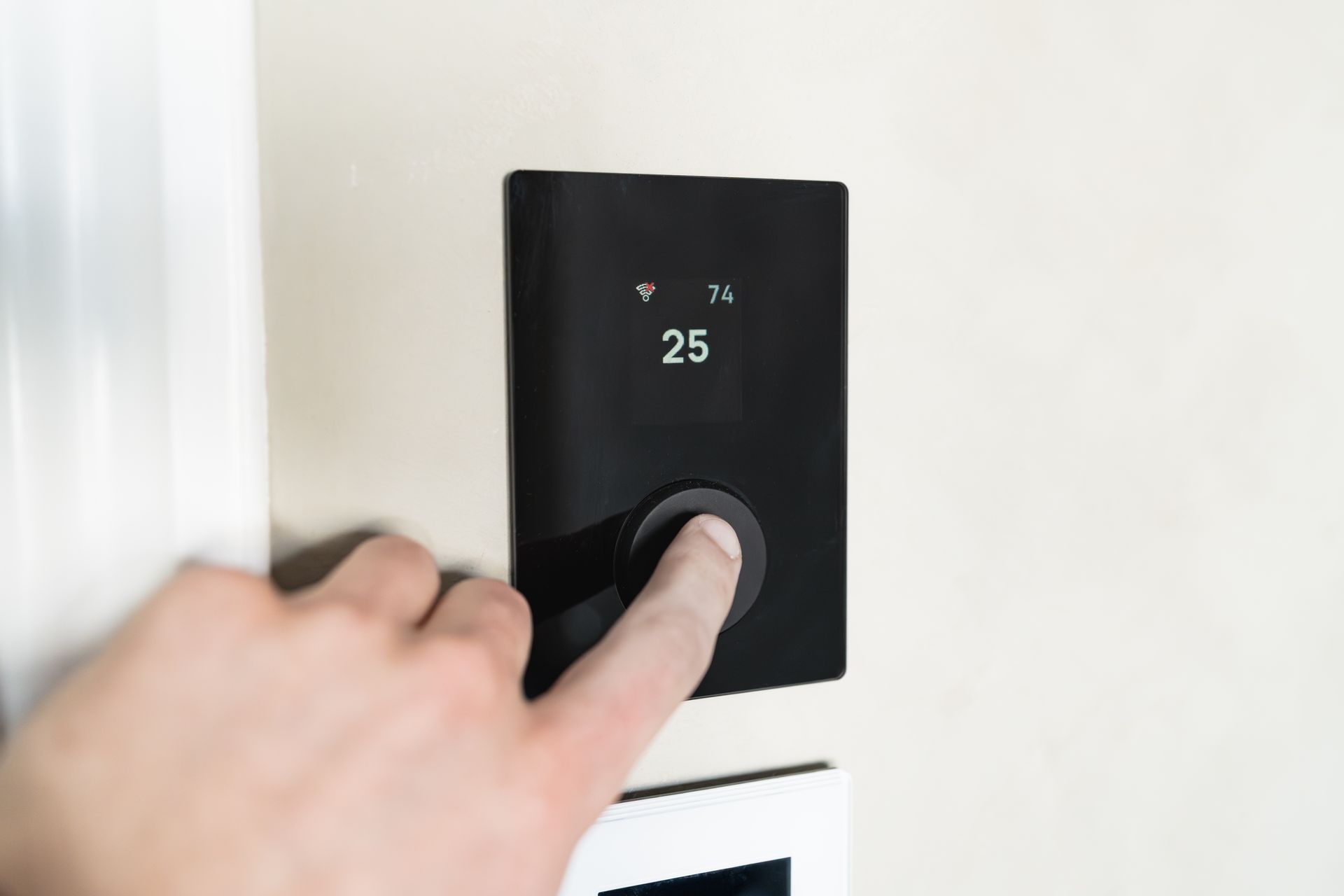 Hand bedient ein modernes Wandthermostat